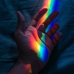 mano con luce arcobaleno