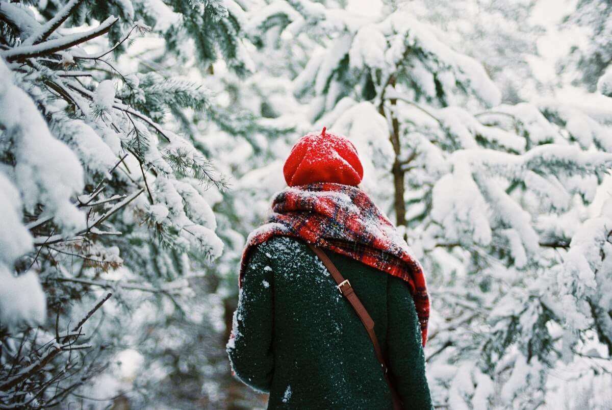 donna-con-sciarpa-in-mezzo-alla-foresta-con-la-neve