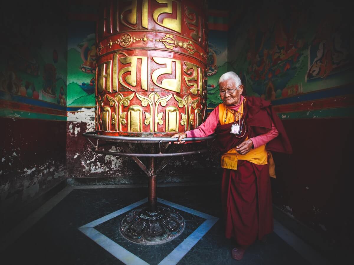 monaco-buddista-anziano-recita-mantra-e-preghiere-in-un-tempio